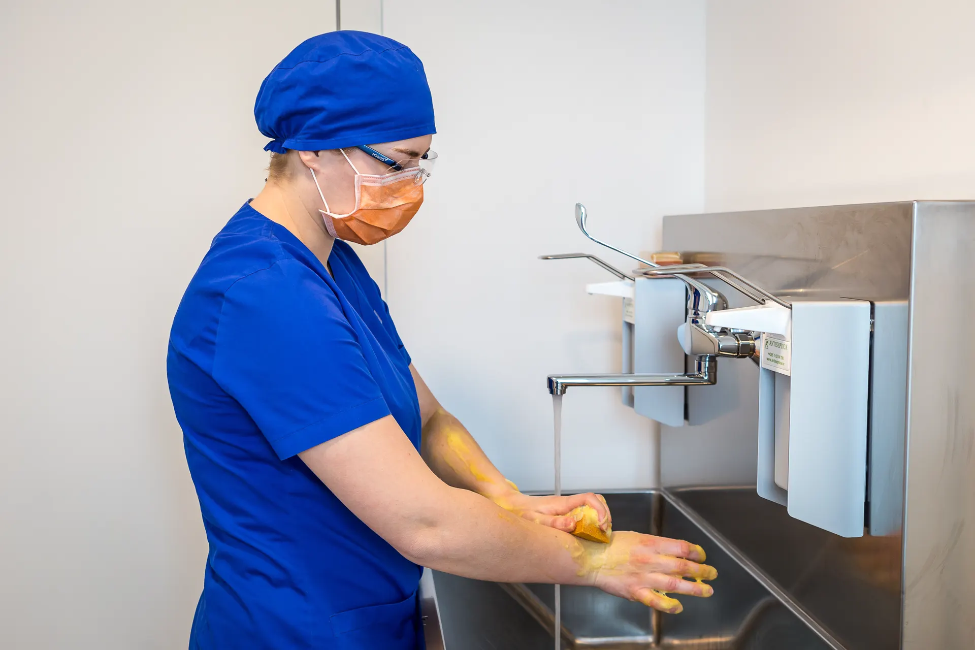 Surgical team member at Ars Salutaris performing pre-operative scrub protocol