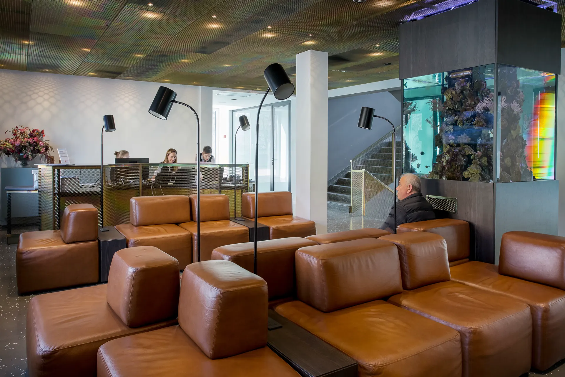 Premium patient waiting area at Ars Salutaris with leather seating, reception, and aquarium feature