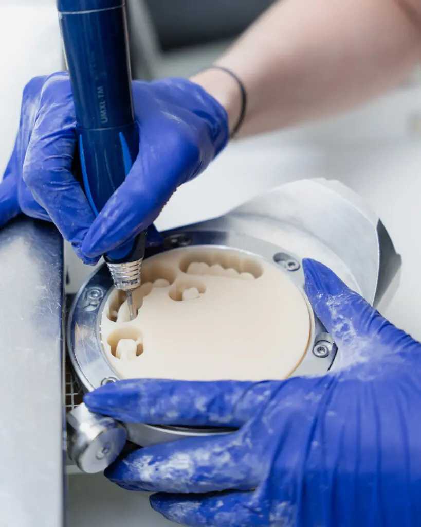 Naturaldent master ceramist hand-finishing a porcelain restoration
